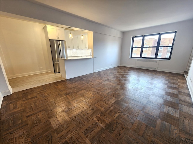 unfurnished living room with radiator and dark parquet floors