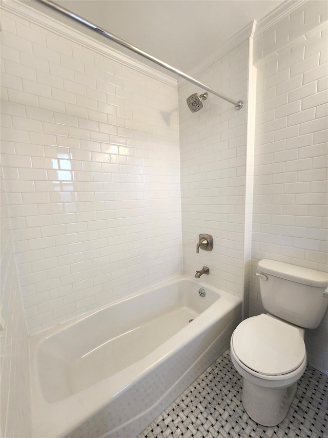 bathroom with crown molding, tile patterned flooring, tiled shower / bath combo, and toilet