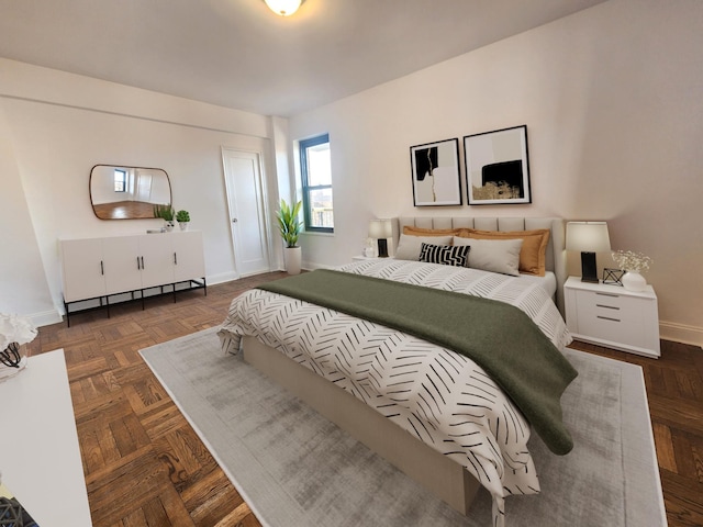 bedroom featuring baseboard heating and dark parquet flooring