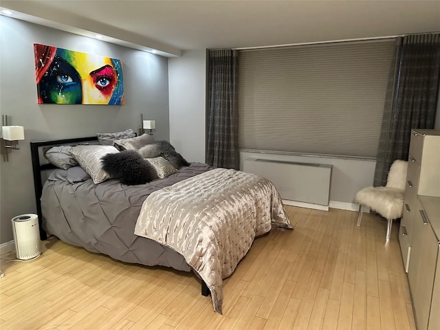 bedroom with radiator and light wood-type flooring