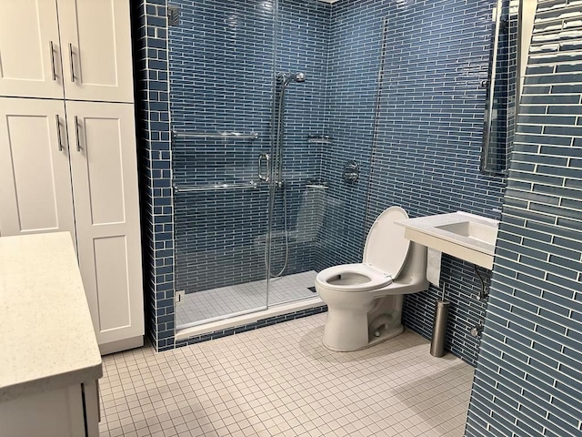 bathroom with tile patterned floors, a shower with door, and tile walls