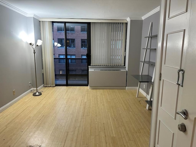 spare room with crown molding and light wood-type flooring