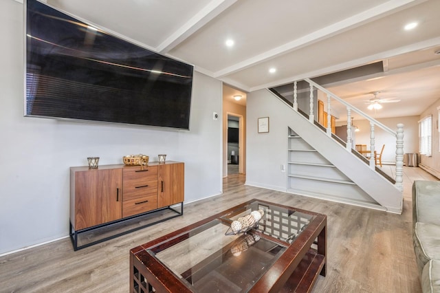 living room featuring hardwood / wood-style flooring, beamed ceiling, and ceiling fan