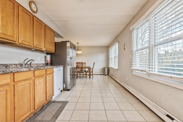 kitchen featuring light tile patterned floors, hanging light fixtures, baseboard heating, sink, and white dishwasher