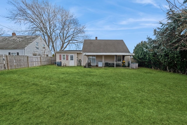 rear view of property featuring a lawn