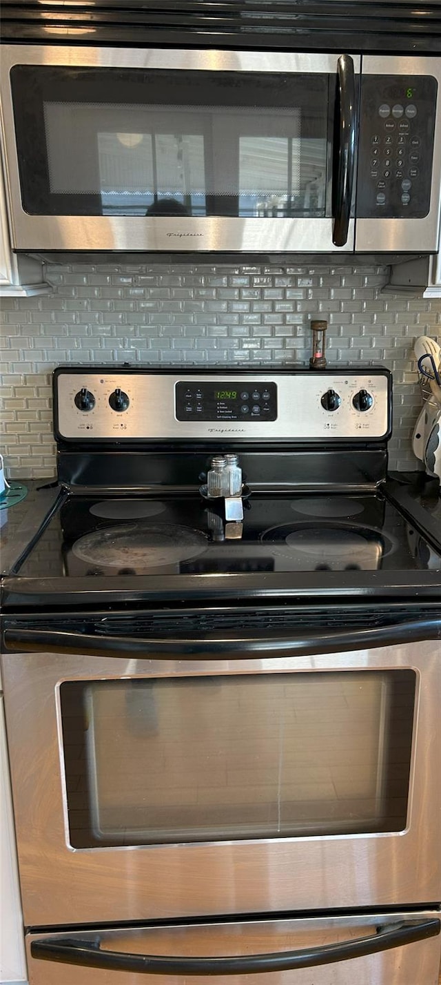 details with tasteful backsplash and appliances with stainless steel finishes