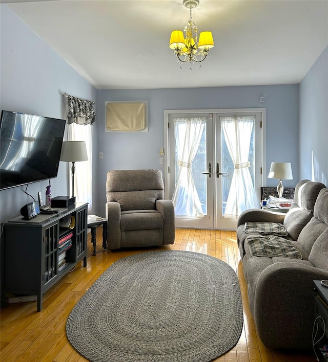 living room featuring french doors, a chandelier, and hardwood / wood-style flooring