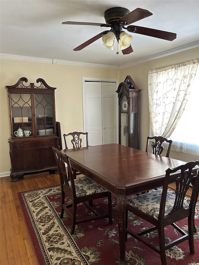 dining space featuring dark hardwood / wood-style flooring, crown molding, and ceiling fan