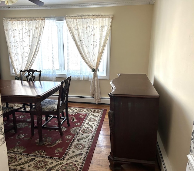 dining area with ornamental molding, a baseboard heating unit, hardwood / wood-style floors, and ceiling fan