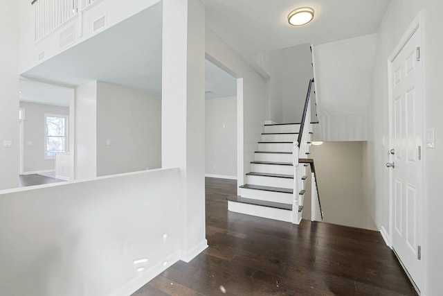 stairs with visible vents, baseboards, and hardwood / wood-style flooring