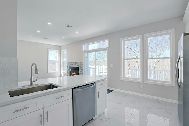 kitchen featuring visible vents, a sink, stainless steel appliances, white cabinets, and baseboards