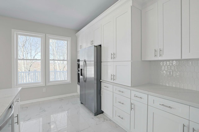 kitchen with light stone counters, baseboards, appliances with stainless steel finishes, marble finish floor, and backsplash