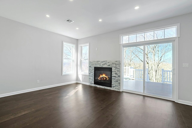 unfurnished living room with dark wood finished floors, visible vents, recessed lighting, and baseboards