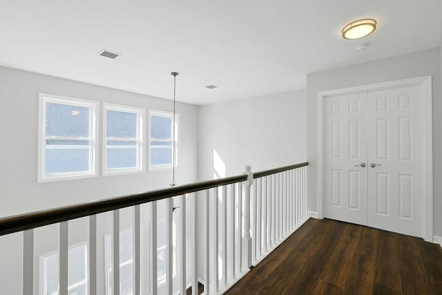 hallway featuring visible vents and dark wood-style flooring