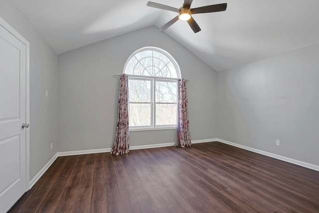 unfurnished room featuring ceiling fan, baseboards, dark wood finished floors, and vaulted ceiling