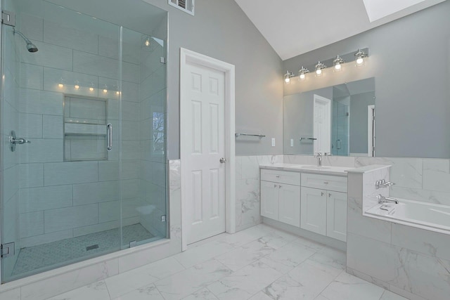 bathroom featuring vaulted ceiling with skylight, vanity, marble finish floor, and a shower stall