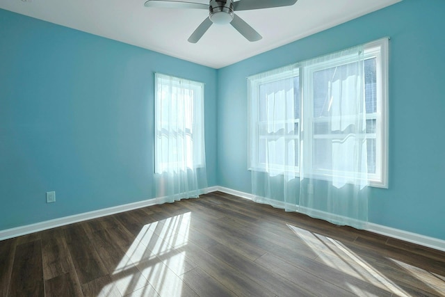 empty room featuring a ceiling fan, dark wood-style floors, and baseboards