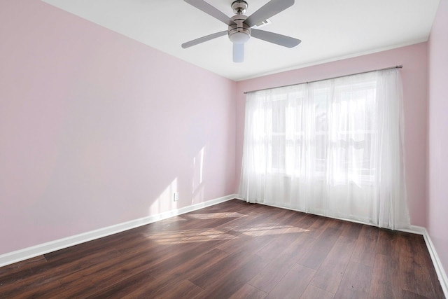 empty room featuring a ceiling fan, dark wood-style floors, and baseboards