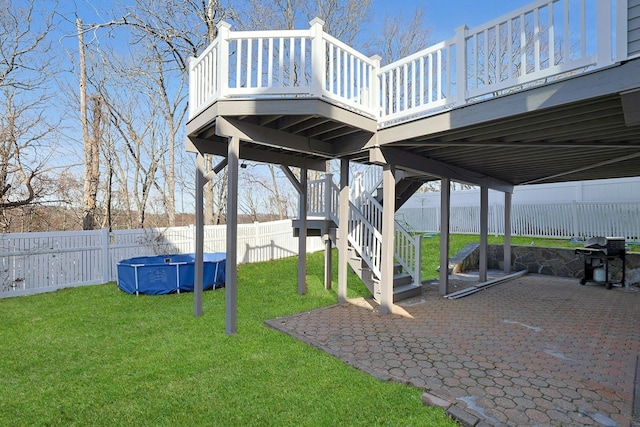 view of yard with a fenced in pool, stairway, a wooden deck, a fenced backyard, and a patio area