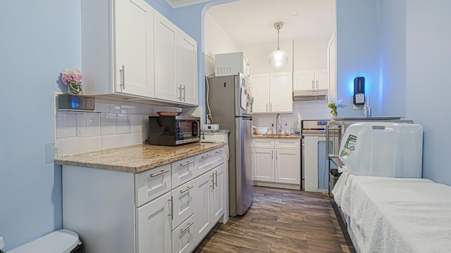 kitchen featuring tasteful backsplash, appliances with stainless steel finishes, dark hardwood / wood-style floors, pendant lighting, and white cabinets