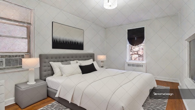 bedroom featuring cooling unit, wood-type flooring, and radiator