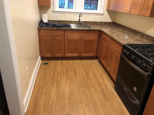 kitchen with sink, black range with gas stovetop, and light wood-type flooring