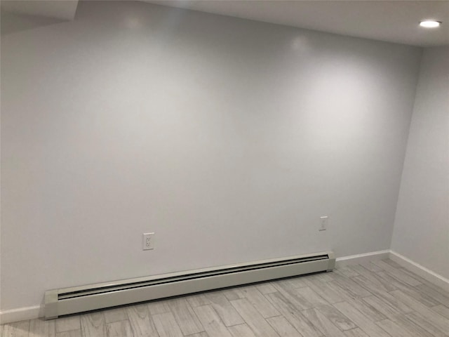 spare room featuring a baseboard radiator and light hardwood / wood-style flooring