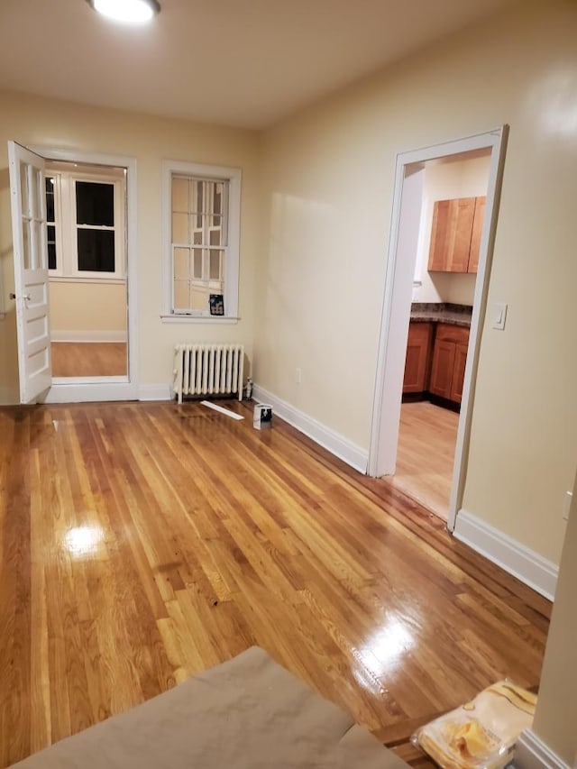 empty room featuring radiator and light hardwood / wood-style floors