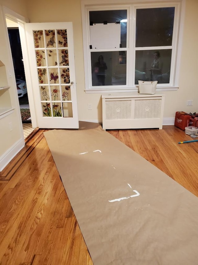 unfurnished dining area with radiator heating unit and light wood-type flooring