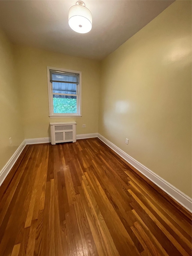 64-18 84th Pl, Middle Village, NY 11379 - spare room featuring dark wood-style flooring, baseboards, and radiator heating unit