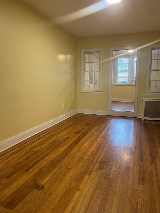 64-18 84th Pl, Middle Village, NY 11379 - unfurnished room featuring radiator, dark wood-style flooring, and baseboards