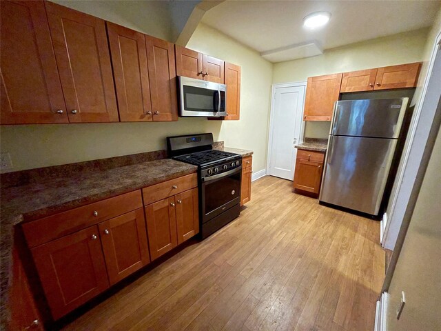 64-18 84th Pl, Middle Village, NY 11379 - kitchen with stainless steel appliances, light wood finished floors, brown cabinets, and dark countertops