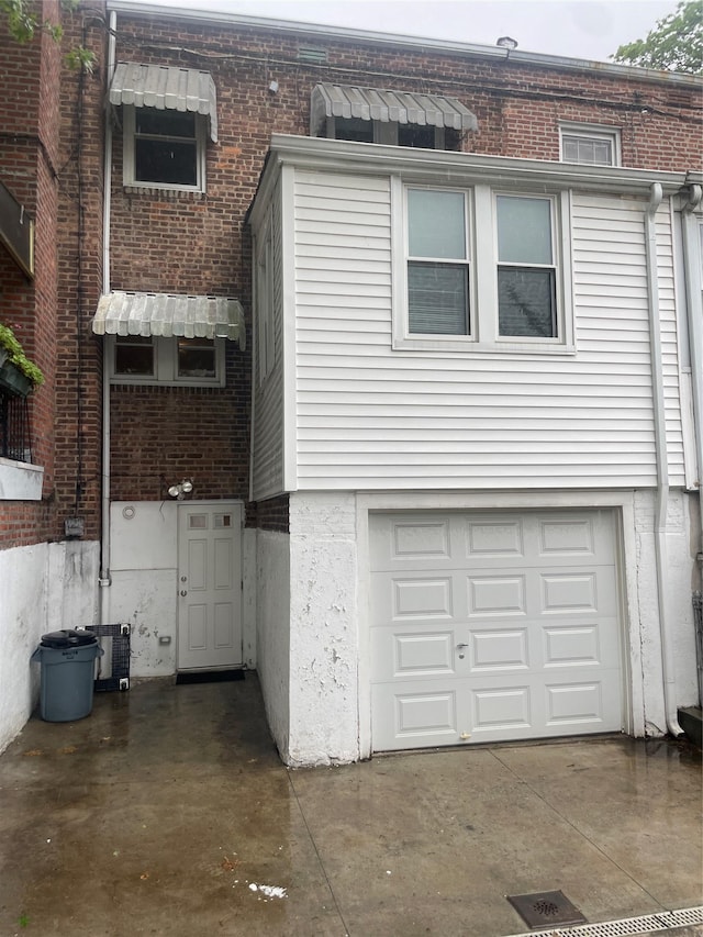 64-18 84th Pl, Middle Village, NY 11379 - view of front of property featuring an attached garage, brick siding, and central AC