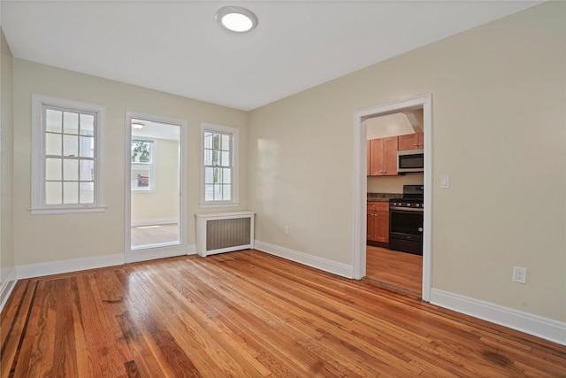 64-18 84th Pl, Middle Village, NY 11379 - unfurnished room featuring radiator and light wood finished floors