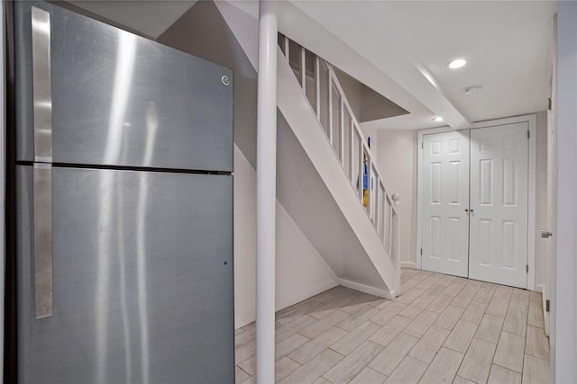 64-18 84th Pl, Middle Village, NY 11379 - finished below grade area with freestanding refrigerator, stairs, wood finished floors, and recessed lighting