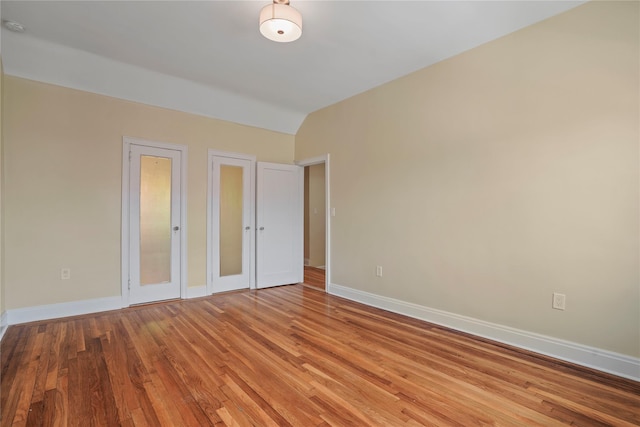 64-18 84th Pl, Middle Village, NY 11379 - unfurnished bedroom featuring light wood-type flooring and vaulted ceiling