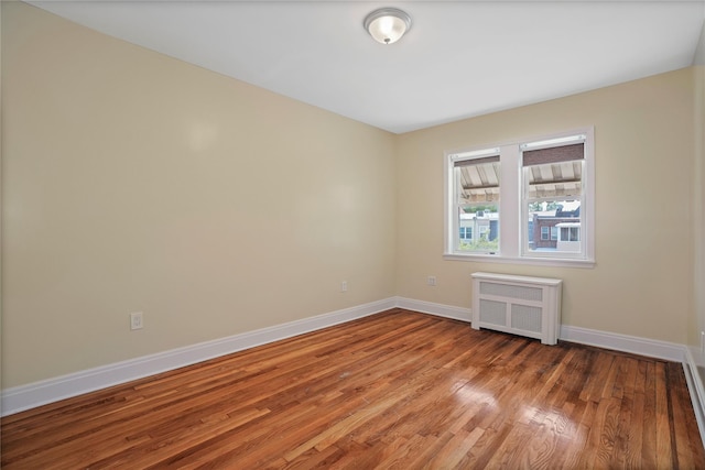 64-18 84th Pl, Middle Village, NY 11379 - empty room with radiator heating unit and wood finished floors