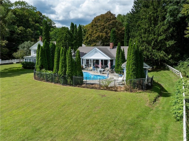 back of property with a patio, a fenced in pool, and a lawn