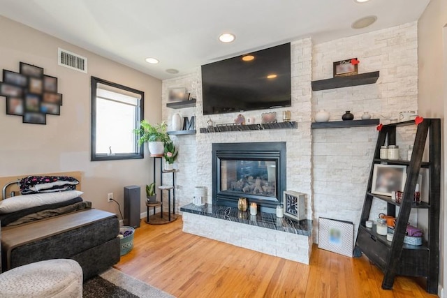 living room with wood-type flooring and a fireplace