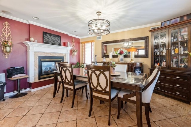 tiled dining space featuring a premium fireplace, ornamental molding, and an inviting chandelier