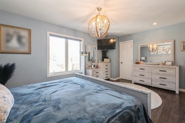 bedroom with dark hardwood / wood-style flooring and an inviting chandelier