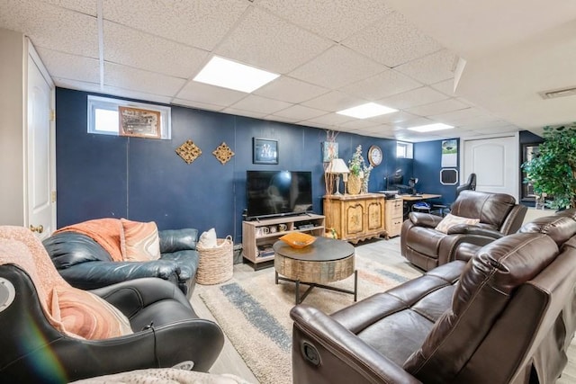 living room featuring light hardwood / wood-style floors and a drop ceiling