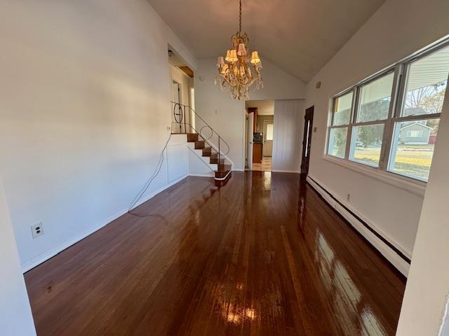 interior space with lofted ceiling, a baseboard heating unit, a notable chandelier, and dark hardwood / wood-style floors