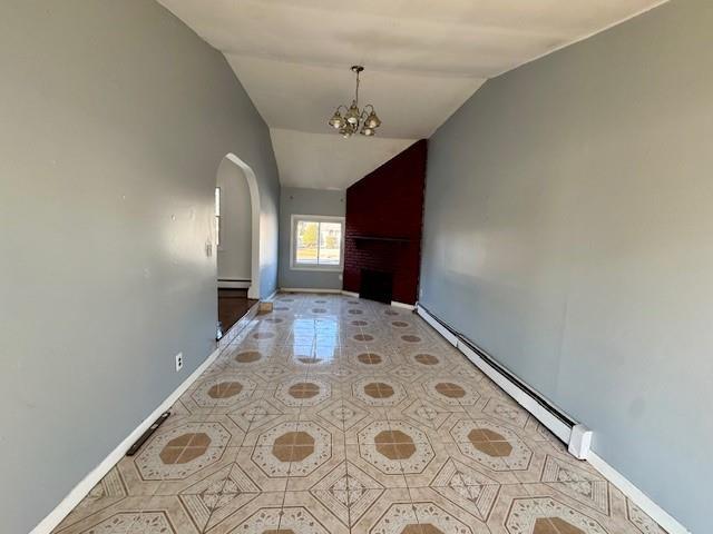 interior space featuring a baseboard heating unit, vaulted ceiling, a chandelier, and light tile patterned flooring