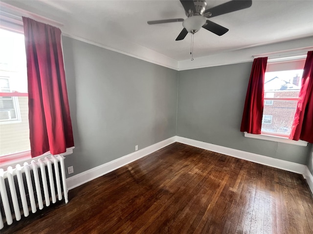 spare room with wood-type flooring, radiator heating unit, and ceiling fan