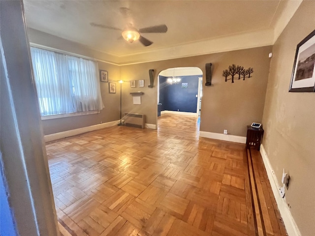 unfurnished room with light parquet floors, radiator heating unit, and ceiling fan with notable chandelier