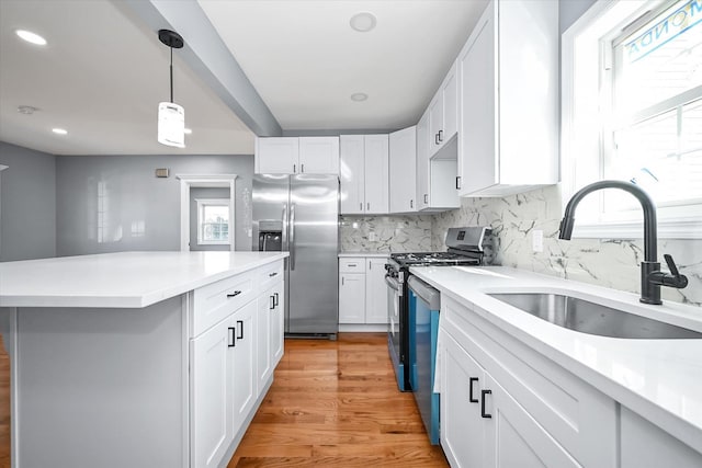 kitchen featuring stainless steel appliances, white cabinetry, sink, and a wealth of natural light