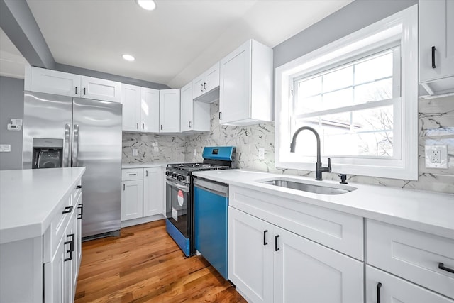 kitchen featuring appliances with stainless steel finishes, sink, white cabinets, and backsplash