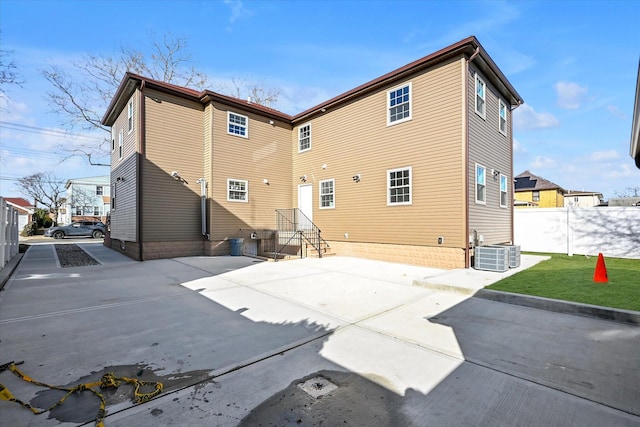 back of property with central AC unit and a patio area