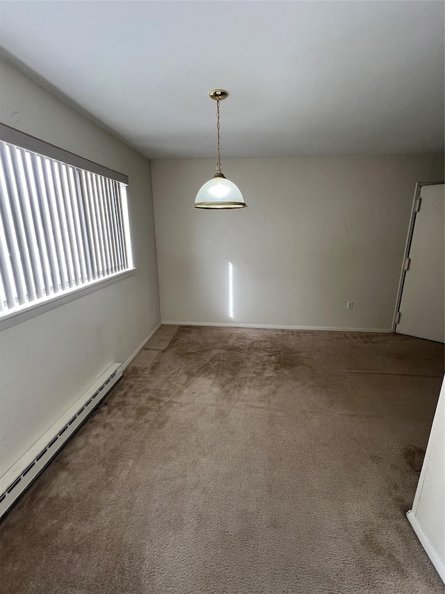 carpeted spare room with a baseboard heating unit